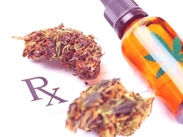 Cannabis flower and cannabis tincture on a prescription pad.