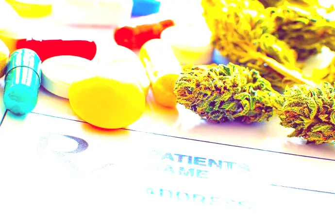 Cannabis Flower and prescription pills on a prescription pad.