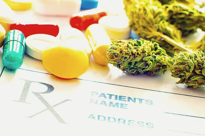Prescription pills and cannabis flower on a prescription page.